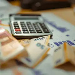 Kalkulator, banknoty euro i wykresy na biurku. Planujesz, jak usunąć zapytania w BIK?