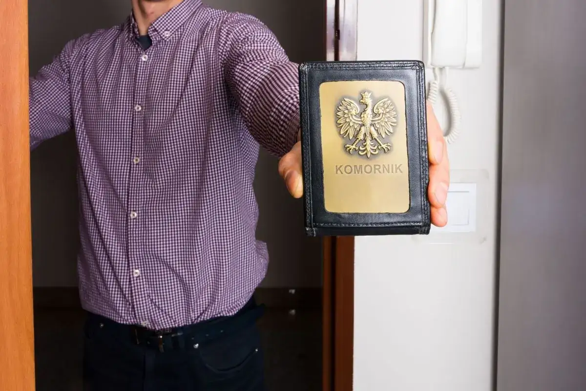 Mężczyzna w koszuli prezentuje legitymację komorniczą. Czy komornik znajdzie mnie za granicą?