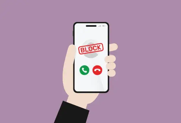 smartfon z ikoną ostrzeżenia o oszustwie lub spamie